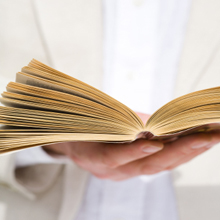 A wedding officiant holding a ceremony book.